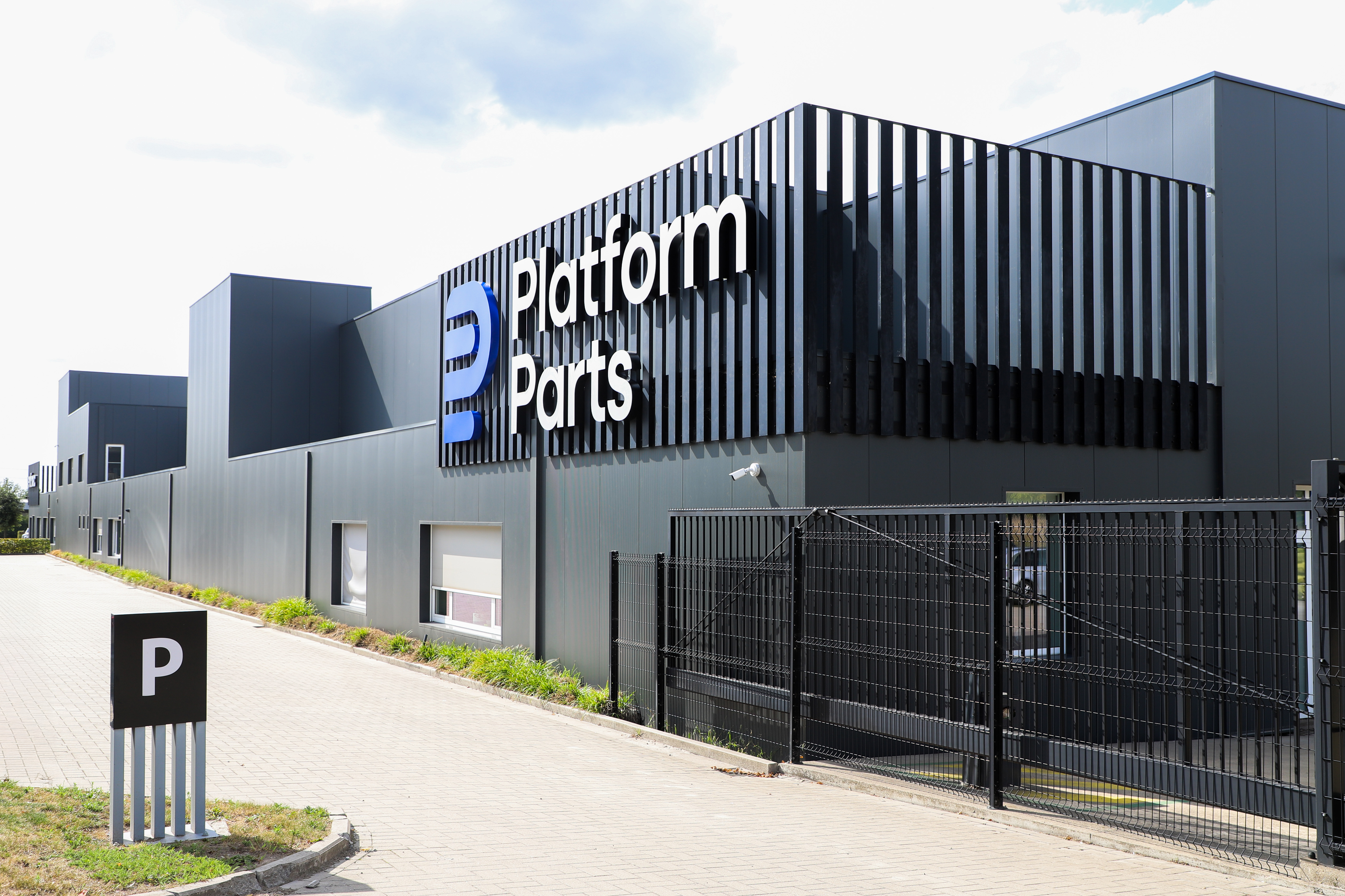 Industrial building with “Platform Parts” logo and blue doors.